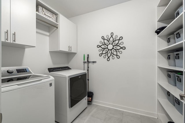 washroom featuring cabinets and separate washer and dryer