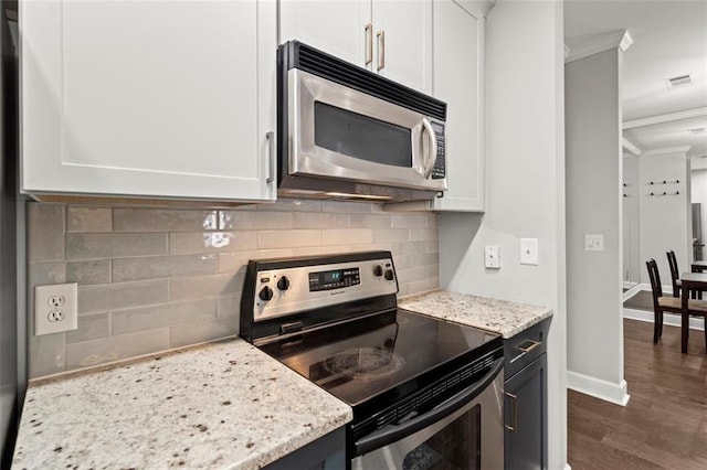 2865 Lenox Rd NE Unit 410, Atlanta, GA 30324 - kitchen featuring stainless steel appliances, white cabinetry, dark wood-type flooring, visible vents, and ornamental molding