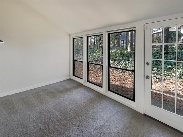 spare room featuring lofted ceiling, plenty of natural light, and carpet flooring