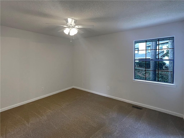 spare room featuring ceiling fan, carpet, and a textured ceiling