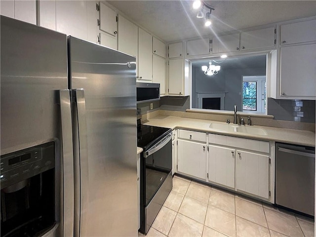 kitchen with white cabinetry, sink, light tile patterned flooring, and appliances with stainless steel finishes