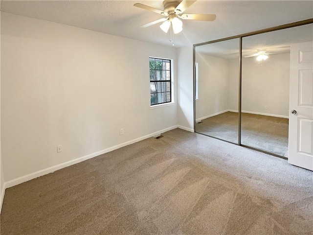 unfurnished bedroom with ceiling fan, a closet, a textured ceiling, and carpet flooring