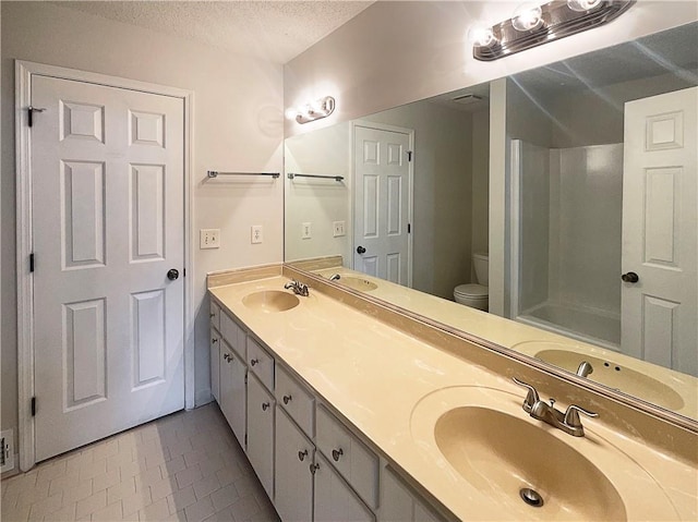 bathroom with vanity, a textured ceiling, and toilet