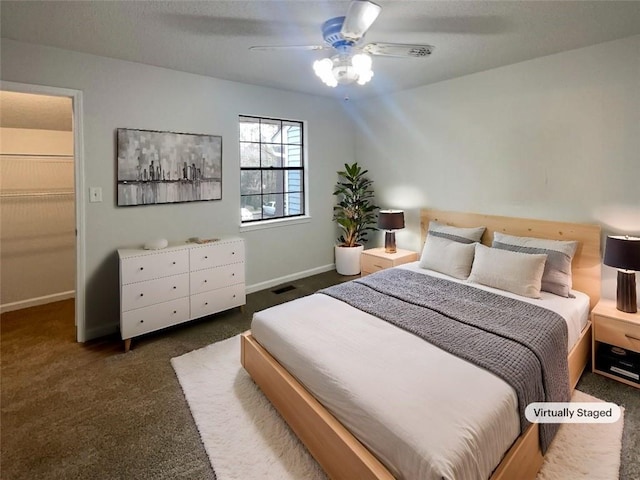 carpeted bedroom with a spacious closet and ceiling fan