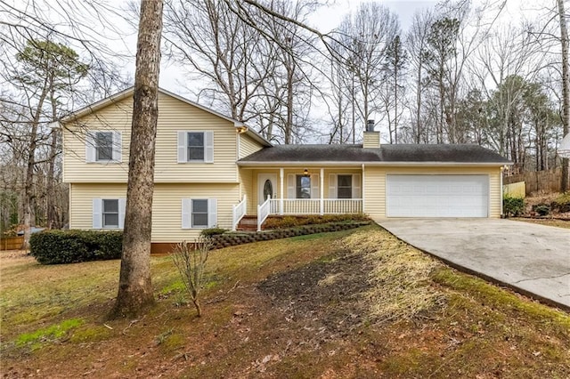 split level home featuring a front lawn, a porch, and a garage