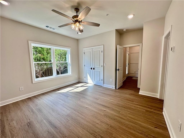 unfurnished bedroom with dark hardwood / wood-style flooring and ceiling fan