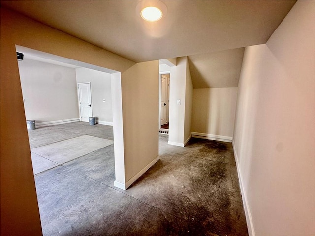 additional living space with concrete flooring and vaulted ceiling