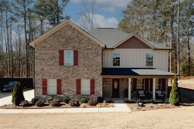 view of front of property featuring a porch, board and batten siding, and brick siding