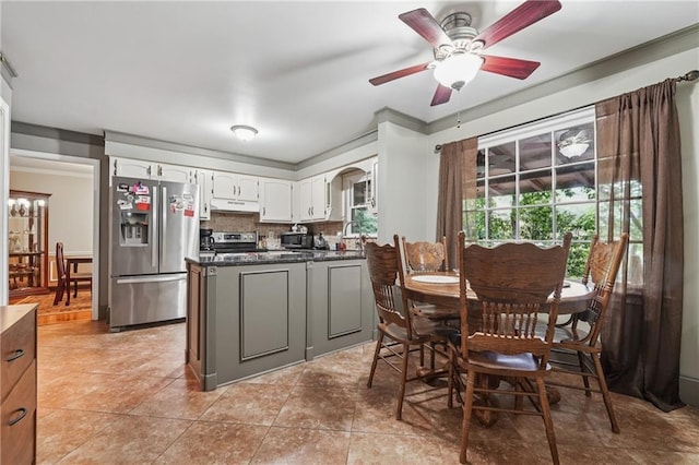 2030 Spring End Ct, Lawrenceville, GA 30044 - kitchen with appliances with stainless steel finishes, under cabinet range hood, dark countertops, white cabinets, and a ceiling fan