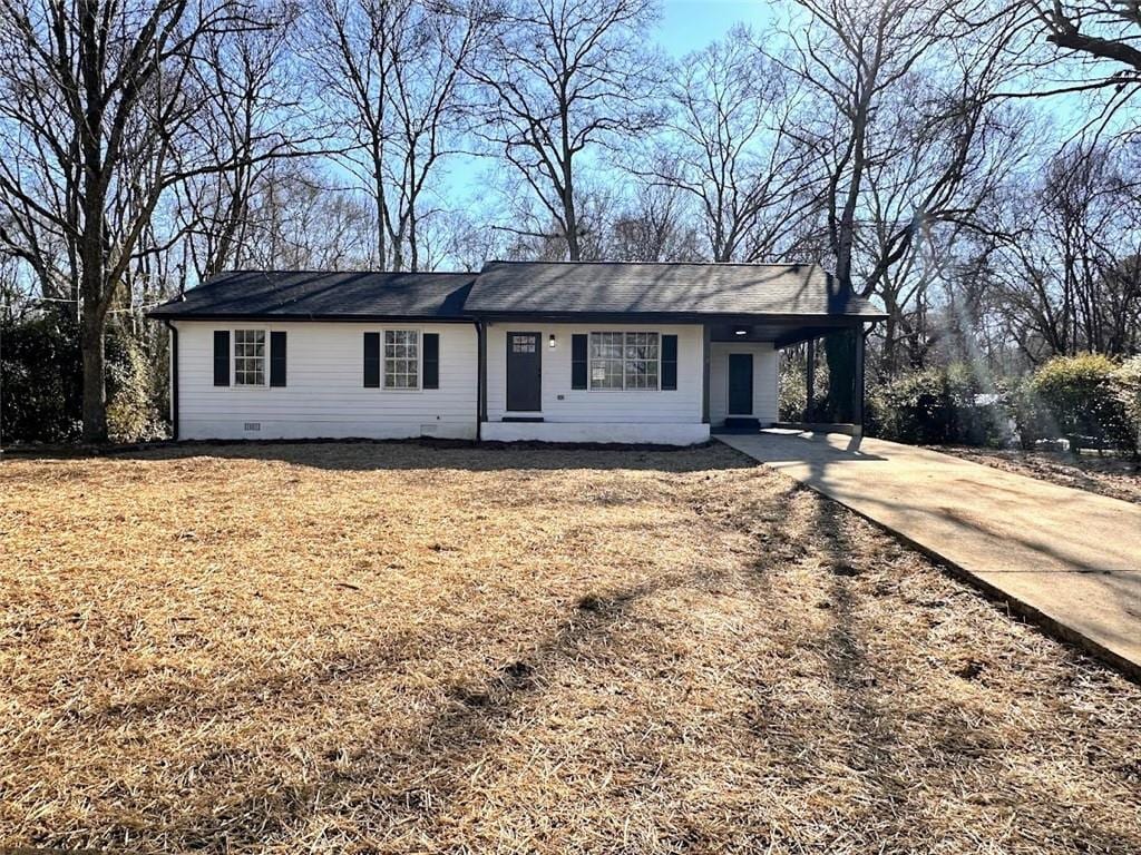 single story home with a front yard and a carport