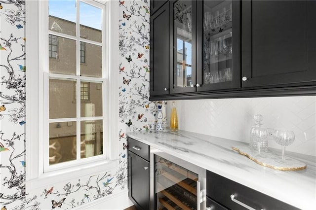 indoor dry bar with wallpapered walls, wine cooler, and backsplash