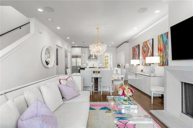 living room with recessed lighting, light wood-style flooring, and an inviting chandelier