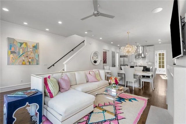 living room featuring recessed lighting, ceiling fan with notable chandelier, wood finished floors, baseboards, and ornamental molding