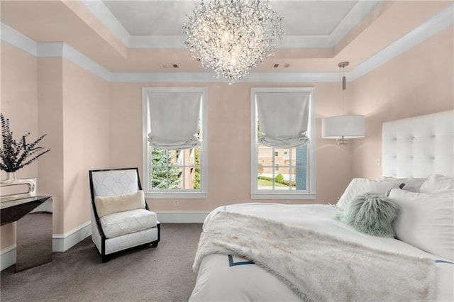 carpeted bedroom with a tray ceiling, a chandelier, and baseboards