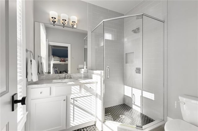bathroom with toilet, a stall shower, and vanity