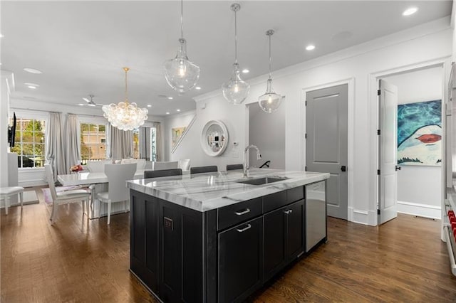 kitchen with dark cabinets, a sink, dishwasher, crown molding, and a kitchen island with sink