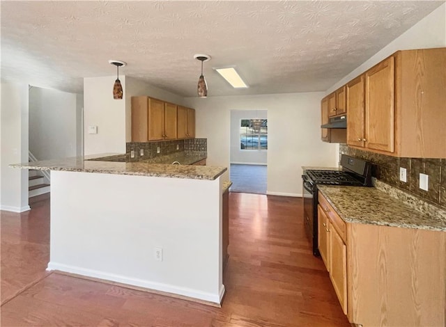 kitchen with dark wood-type flooring, hanging light fixtures, decorative backsplash, gas stove, and kitchen peninsula