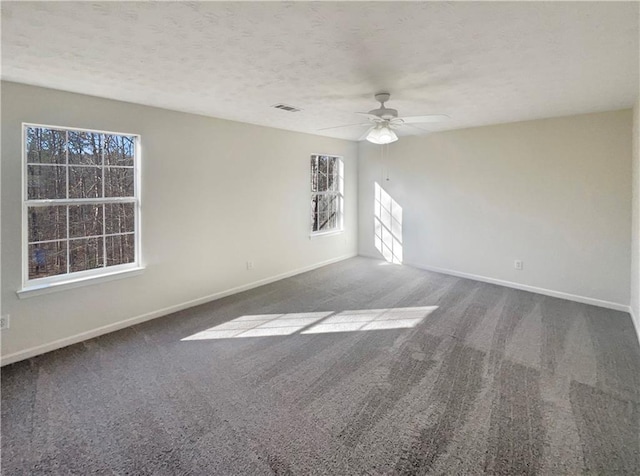 empty room featuring carpet flooring, ceiling fan, and a textured ceiling