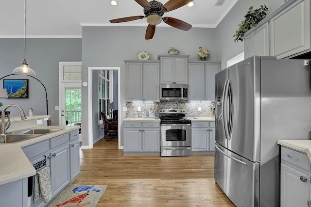 5581 River Valley Way, Flowery Branch, GA 30542 - kitchen featuring stainless steel appliances, a sink, ornamental molding, decorative backsplash, and light wood finished floors