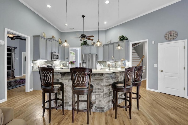 5581 River Valley Way, Flowery Branch, GA 30542 - kitchen featuring gray cabinets, ceiling fan, appliances with stainless steel finishes, a high ceiling, and a kitchen breakfast bar