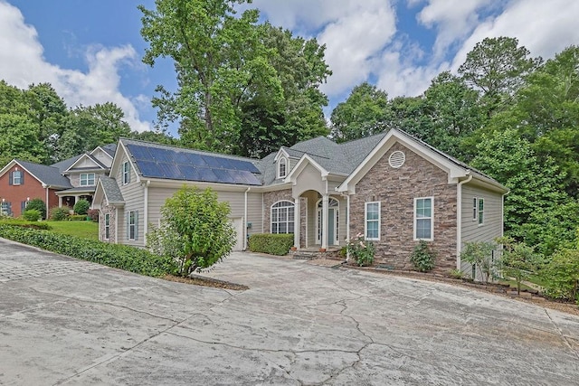 5581 River Valley Way, Flowery Branch, GA 30542 - view of front of house featuring stone siding, roof mounted solar panels, and driveway