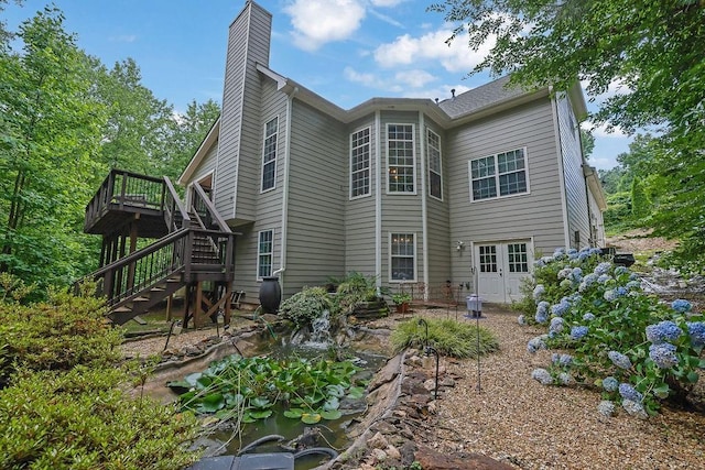5581 River Valley Way, Flowery Branch, GA 30542 - back of property with stairs, a wooden deck, a chimney, and a garden pond