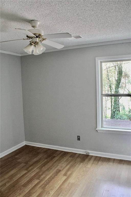 unfurnished room featuring a ceiling fan, a textured ceiling, baseboards, and wood finished floors