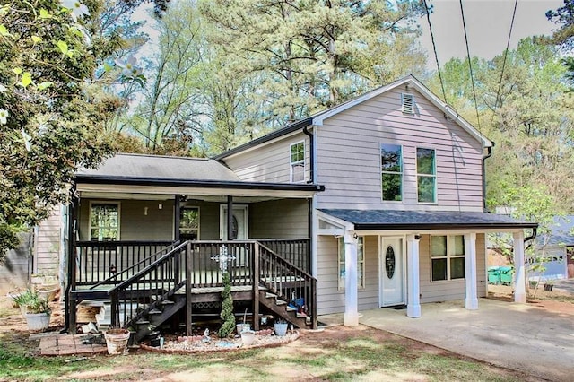 view of front facade with covered porch, a patio, stairway, and roof with shingles