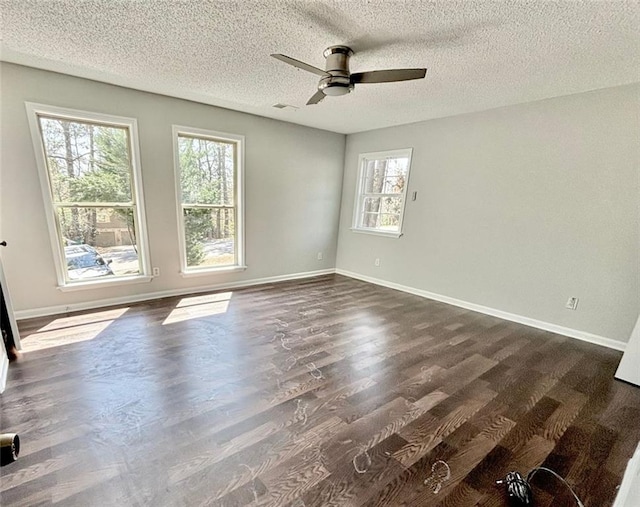 unfurnished room with a ceiling fan, dark wood-style flooring, baseboards, and a textured ceiling