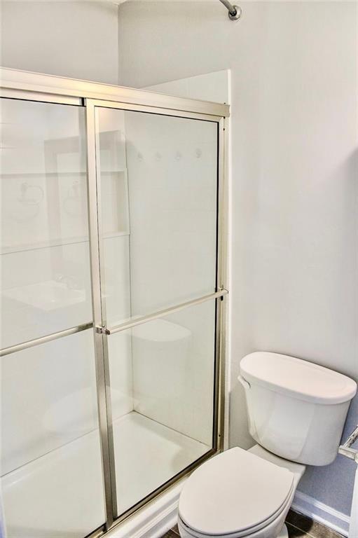 full bath with toilet and a shower stall
