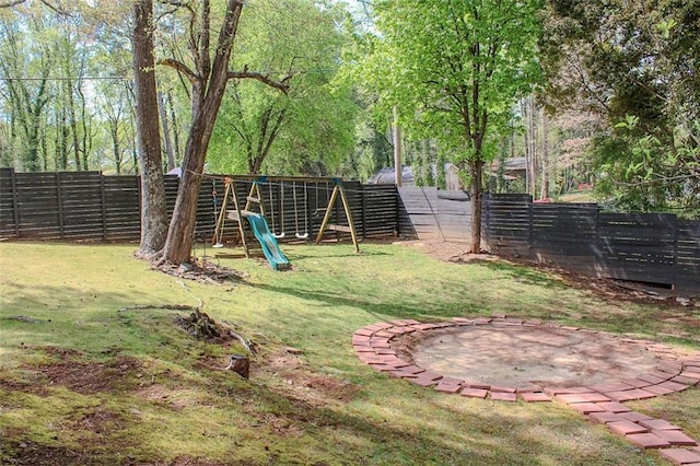 view of yard with a fenced backyard and a playground