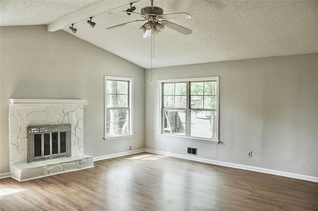 unfurnished living room featuring vaulted ceiling with beams, wood finished floors, ceiling fan, and baseboards