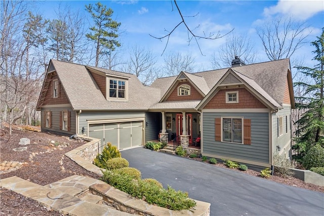 craftsman-style home featuring aphalt driveway and a shingled roof