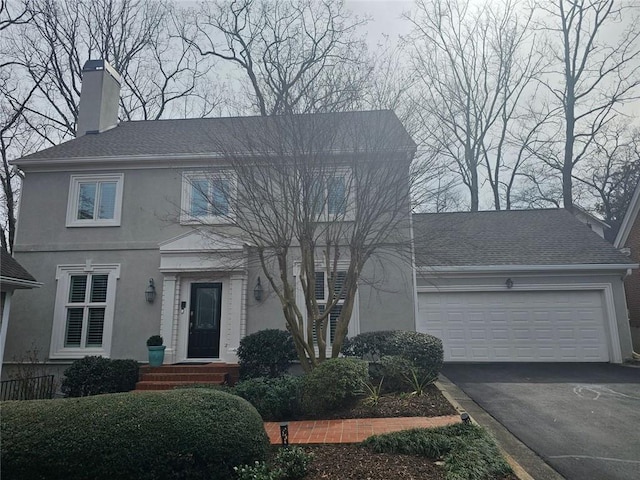 view of front of house featuring a garage, aphalt driveway, a shingled roof, and stucco siding