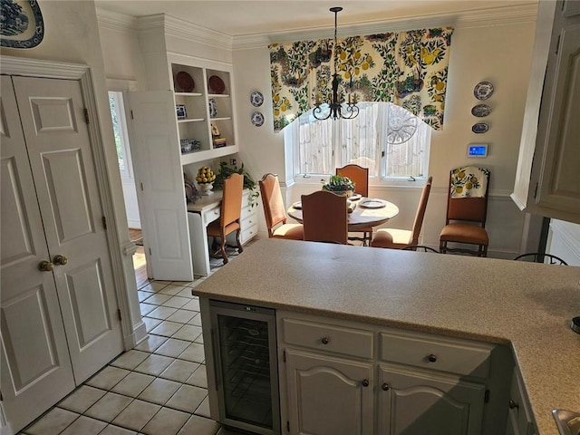 kitchen featuring wine cooler, crown molding, light tile patterned floors, light countertops, and hanging light fixtures