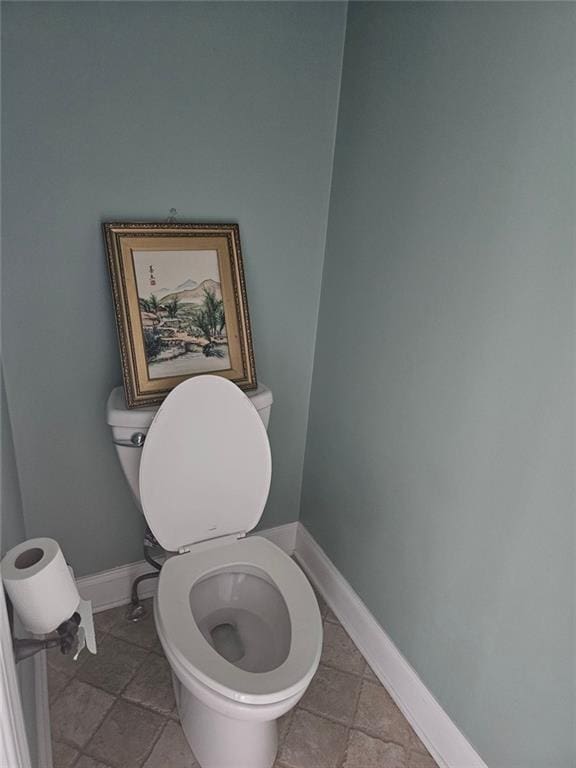 bathroom featuring toilet and baseboards