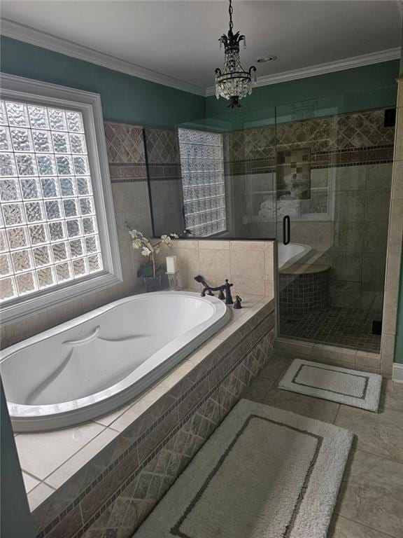 full bath with a garden tub, tile patterned flooring, an inviting chandelier, crown molding, and a shower stall