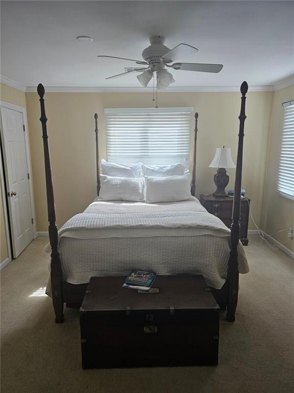 carpeted bedroom featuring ornamental molding, ceiling fan, and baseboards