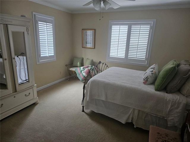 carpeted bedroom with a ceiling fan, baseboards, and crown molding