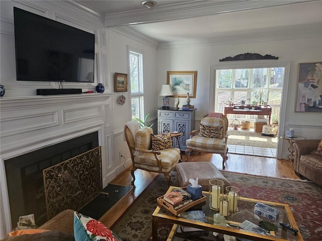 living room with a fireplace, a wealth of natural light, and crown molding