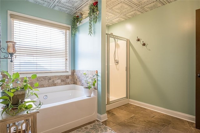 2235 Well Springs Dr, Buford, GA 30519 - bathroom with an ornate ceiling, a bath, a stall shower, and baseboards