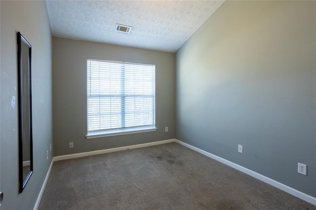 carpeted spare room with visible vents, a textured ceiling, and baseboards