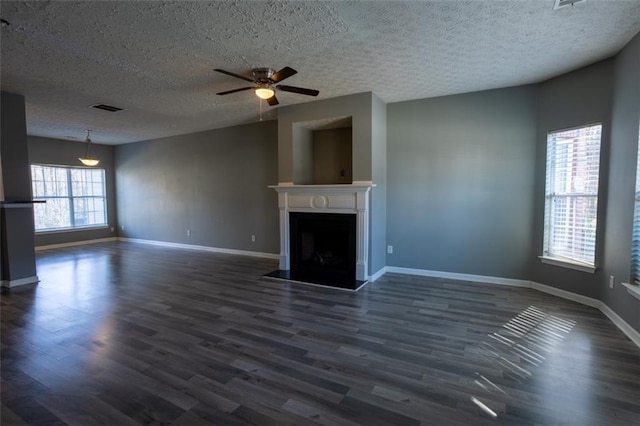 unfurnished living room featuring baseboards, a fireplace, visible vents, and dark wood finished floors