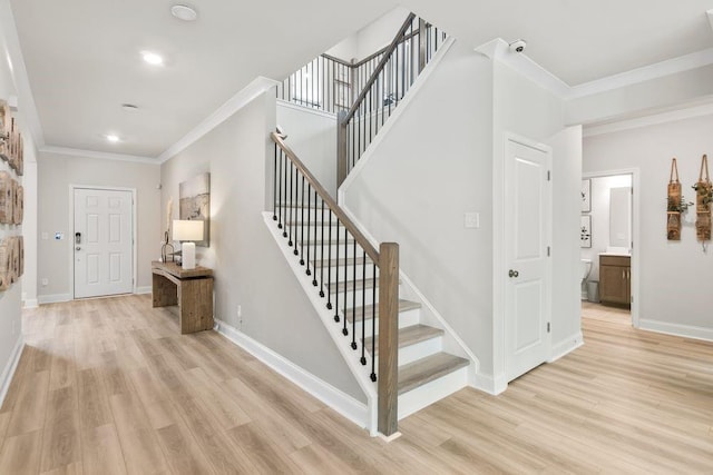 stairway with crown molding, baseboards, and wood finished floors