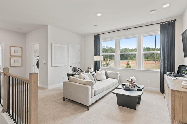 living area with baseboards, recessed lighting, washer / dryer, and light colored carpet