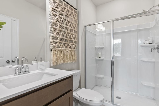 bathroom featuring a stall shower, vanity, and toilet