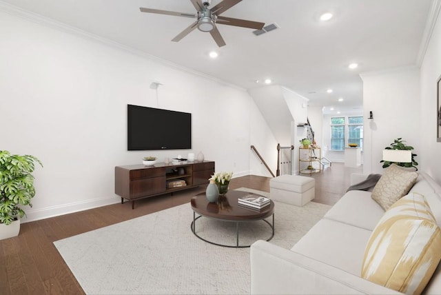 living room with dark hardwood / wood-style flooring, crown molding, and ceiling fan