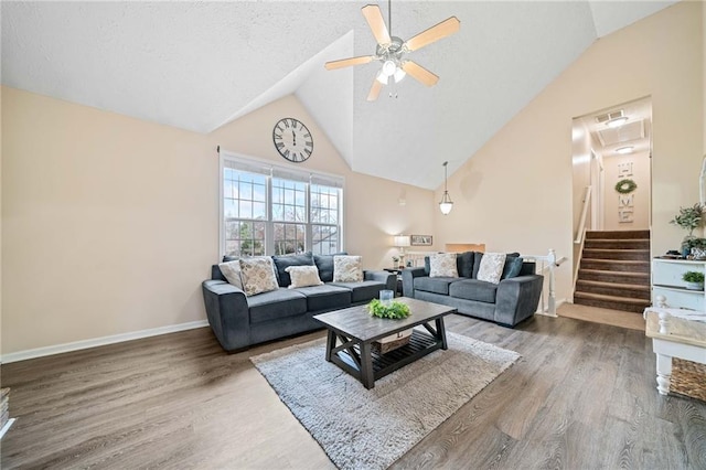 living room featuring a ceiling fan, stairway, baseboards, and wood finished floors