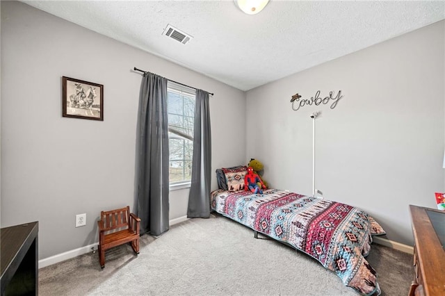 carpeted bedroom featuring visible vents, a textured ceiling, and baseboards