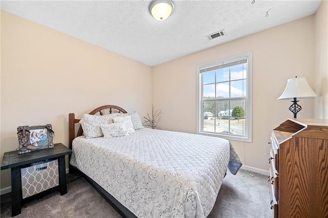 bedroom with visible vents, dark carpet, a textured ceiling, and baseboards